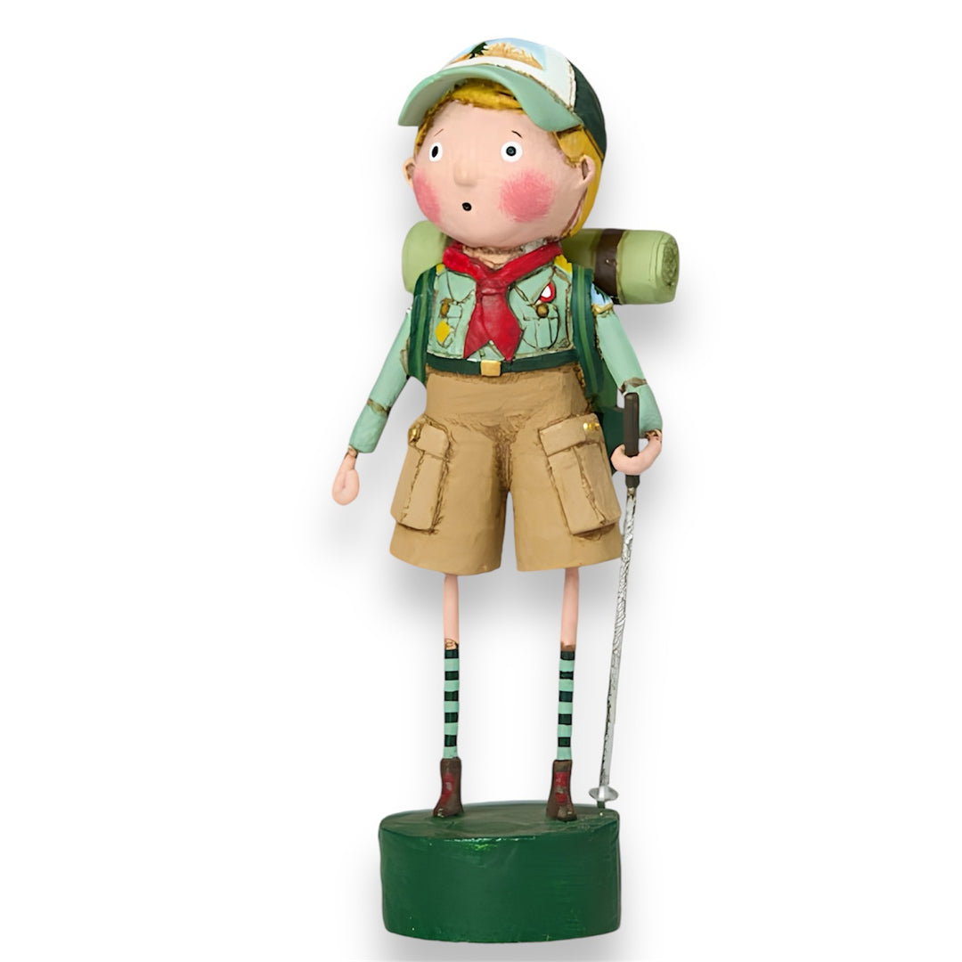 A handpainted figurine of a cartoon-style boy scout wearing a green uniform and a hat, standing on a green base.