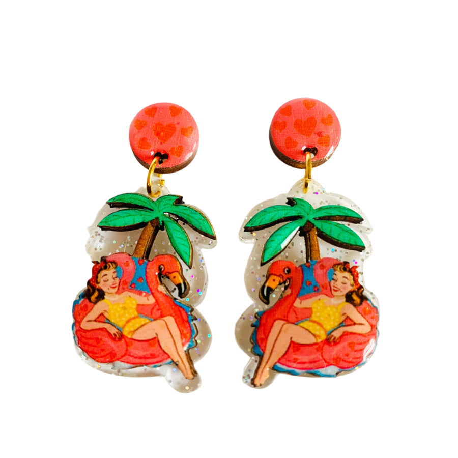 Tropical-themed earrings with a woman in a swimsuit and flamingo on a white background