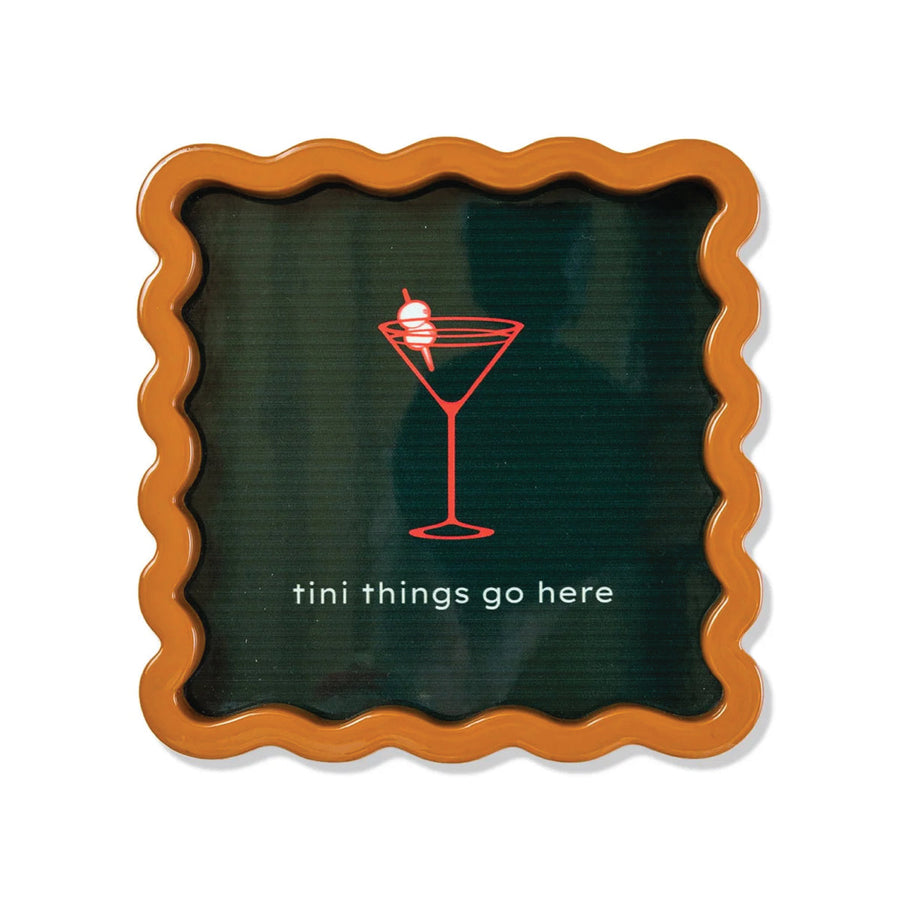 Decorative tray with wavy edge, dark green center, and red cocktail illustration with text 'tini things go here'.