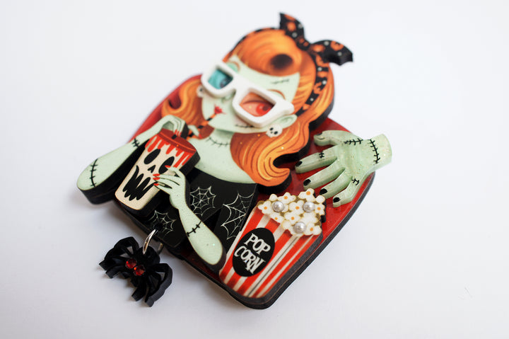 Zombie girl brooch close-up — cinema viewer with popcorn and spider — Halloween acrylic glitter jewelry — LaliBlue Midnight Cinema