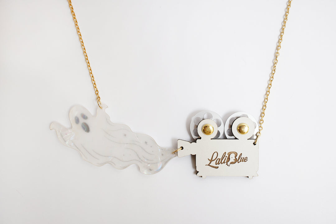 Ghost film projector necklace angle view — articulated Halloween cinema acrylic jewelry — LaliBlue Midnight Cinema
