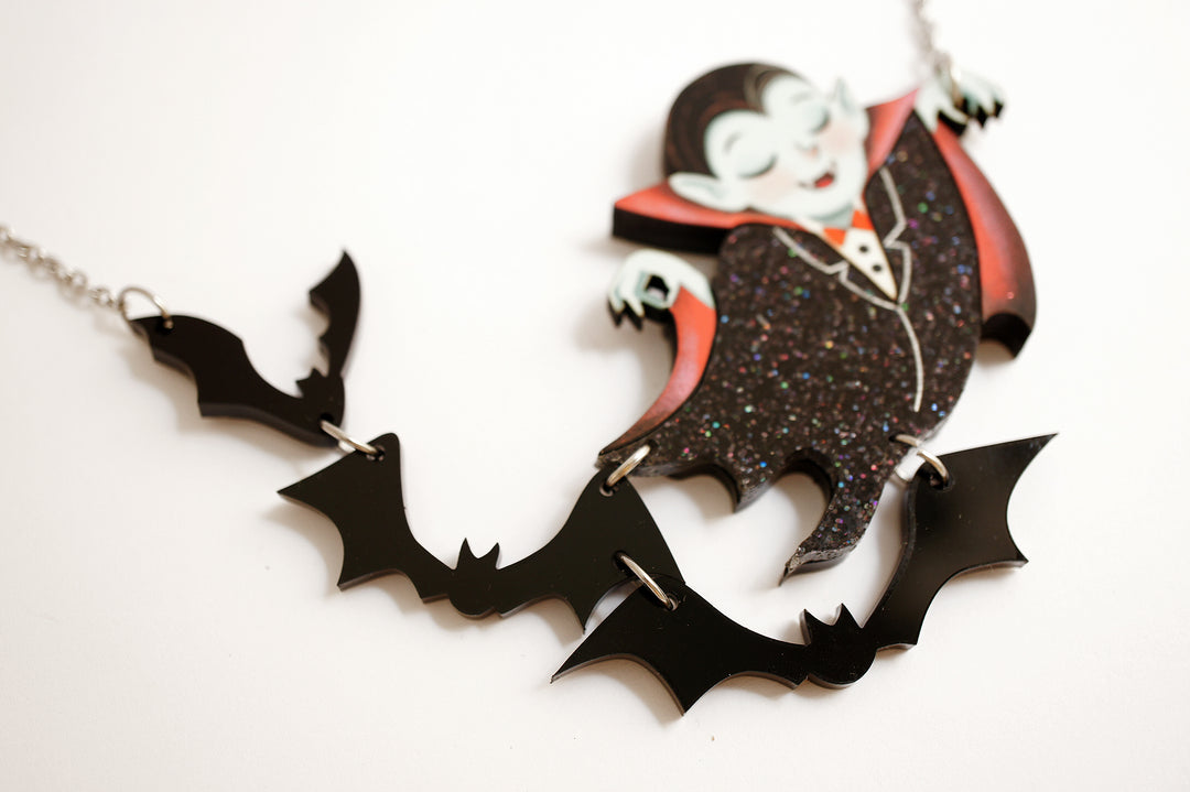 Dracula flying bats necklace close-up — articulated Halloween acrylic illustrated wood jewelry — LaliBlue Midnight Cinema
