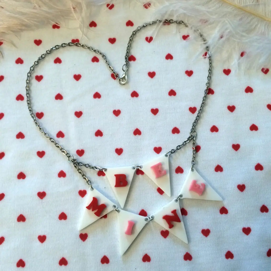 Necklace with heart-shaped pendants on a white background with red heart patterns