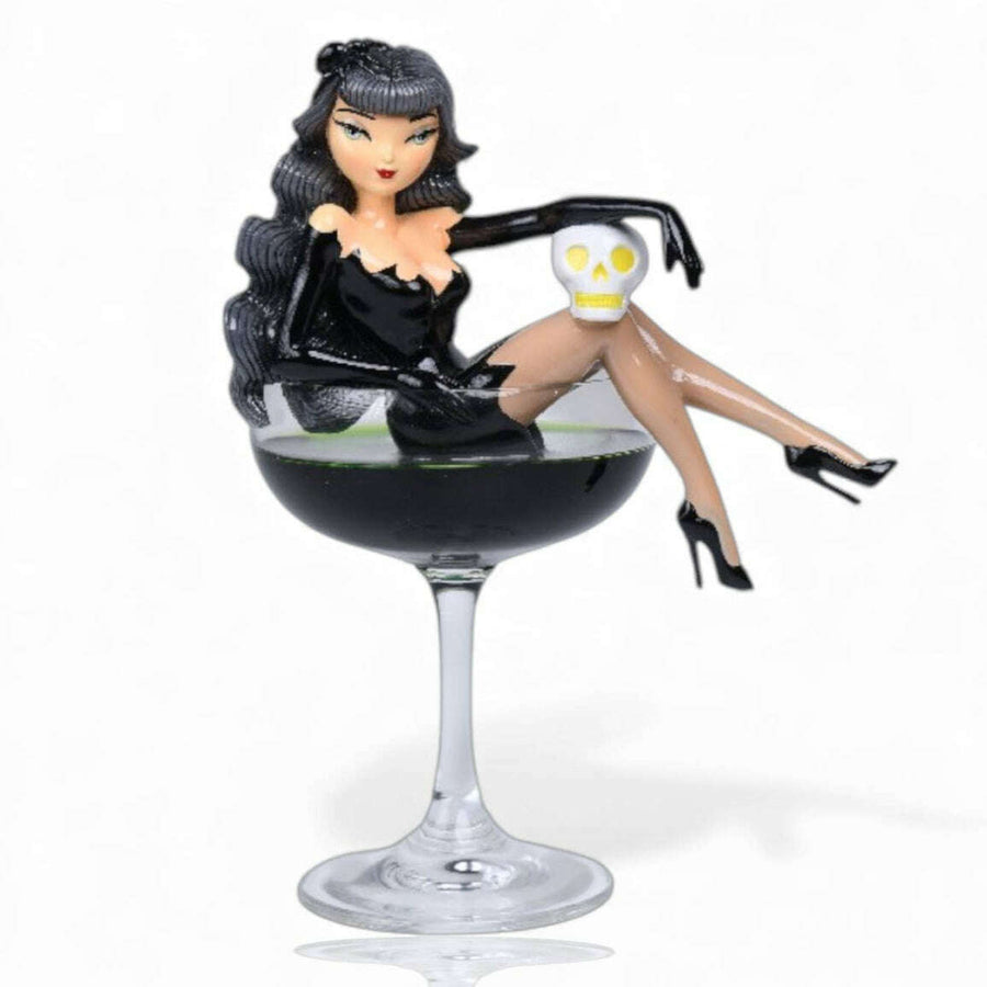 black widow woman in a black dress sitting on a wine glass with a skull in a cocktail. miss fluff december diamonds