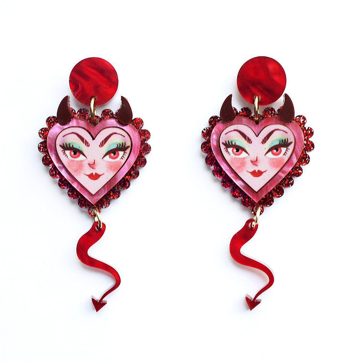 Heart-shaped earrings with face design and red ribbons on a white background