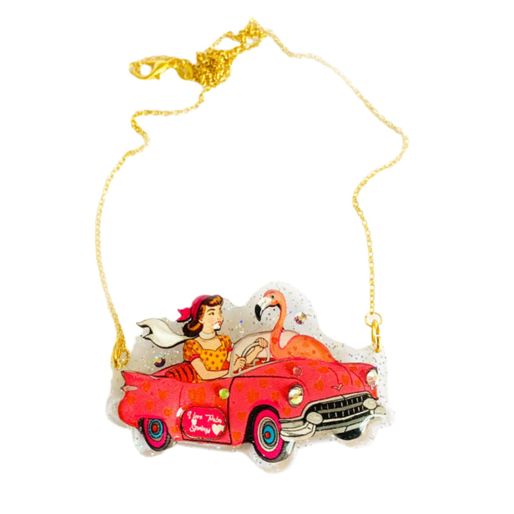Necklace with a pendant of a woman in a red car and flamingo on a white background