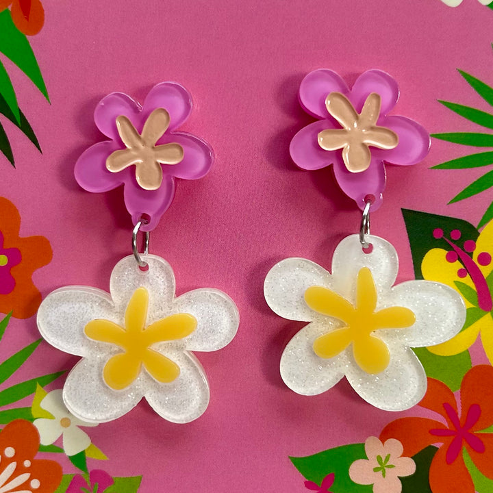 Flower-shaped earrings on a colorful floral background