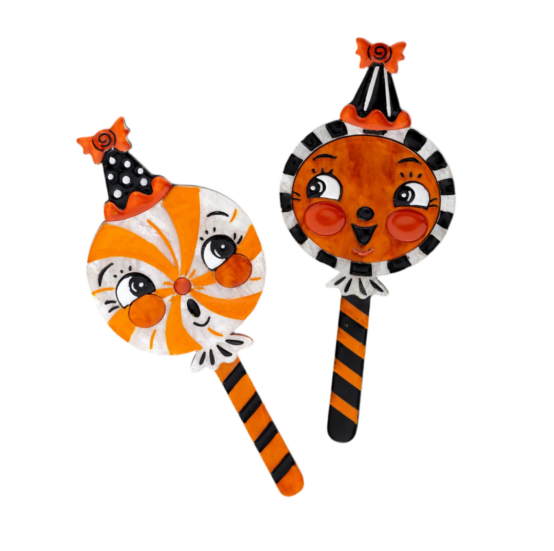 A set of two colorful brooches designed with cartoonish faces, one predominantly orange with black stripes and the other with a black and white striped body, against a white background.