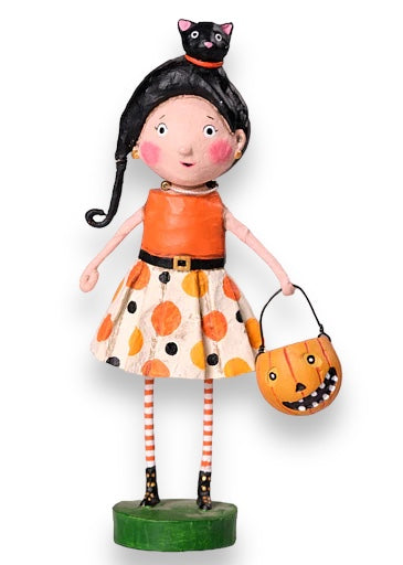 Hand painted resin figurine of a girl dressed in a Halloween costume, holding a pumpkin-shaped bucket, with a black cat on her head, on a green base. kit kat lori mitchell halloween