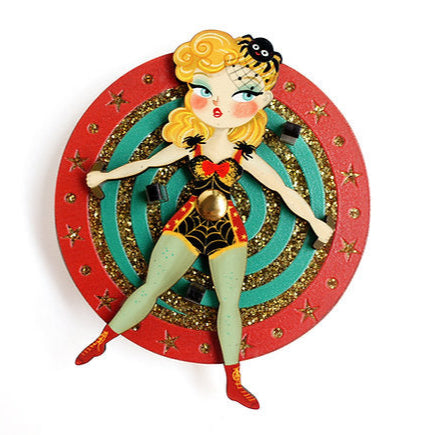 Retro-inspired circus-style brooch.

Spin the wheel… suspense guaranteed!

Inspired by classic knife shows, this brooch pays homage to the precision, strategy, and stagecraft of vintage circus greats.

Made of wood and acrylic, it represents a circus performer on a roulette wheel with three knives perfectly positioned around her.

An illustrated piece that combines humor and a theatrical touch.

-Very light and eye-catching

 -Diameter of 6 cm
-Made of wood and acrylic
-UV printing
-Safety lock on the back
