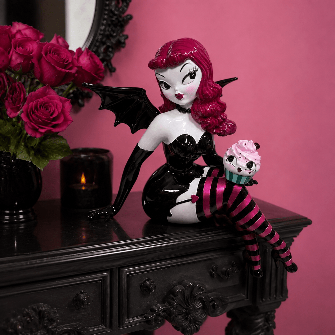 Meet Verna Bat Girl, one of the showstoppers from the newest Miss Fluff x December Diamonds collection. Standing an incredible 27.5 inches tall, she’s equal parts spooky, glamorous, and delightfully whimsical.

From her dramatic bat wings and vintage pin-up style to her striped stockings and mischievous cupcake companion, every inch is packed with the signature details Miss Fluff collectors love. Whether she’s perched on a shelf, entry table, or mant