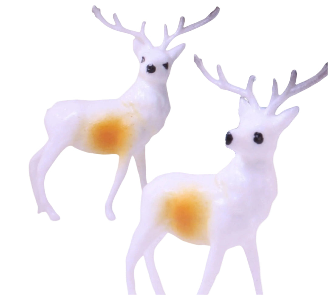 Two white deer figurines with yellow bellies on a white background