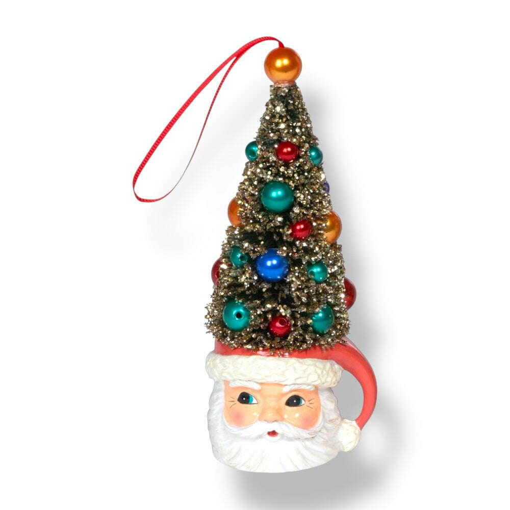 Two holiday-themed mug ornaments, one with a Santa face and the other with a deer, both topped with miniature sisal trees decorated with colorful ornaments and a red ribbon for hanging.