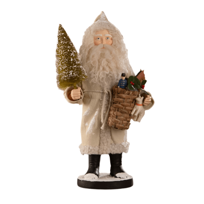A small figurine of Santa Claus with a toy basket and a miniature Christmas tree, dressed in a rustic tan coat, part of the Bethany Lowe Designs collection.