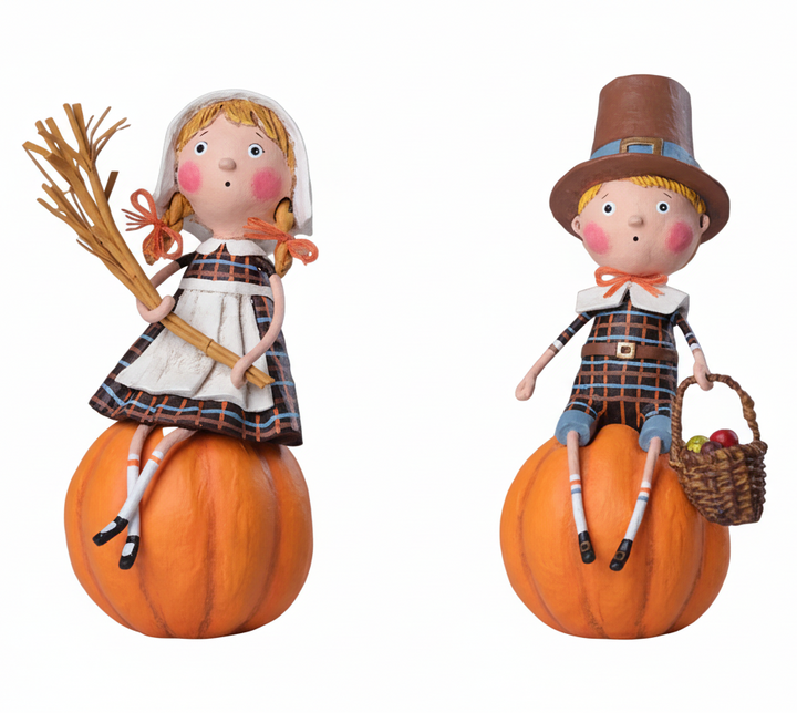 Two figurines of a girl and boy on pumpkins with a white background