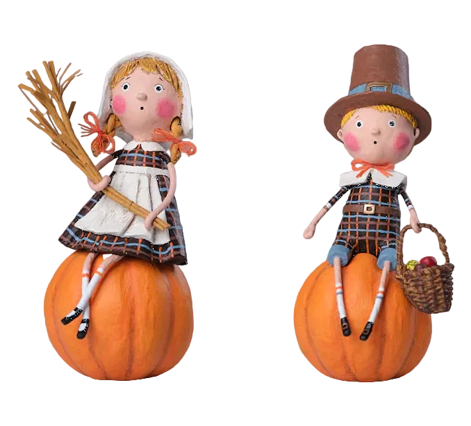 Two dolls on pumpkins, one in a pilgrim outfit and the other in a colonial dress, on a white background.